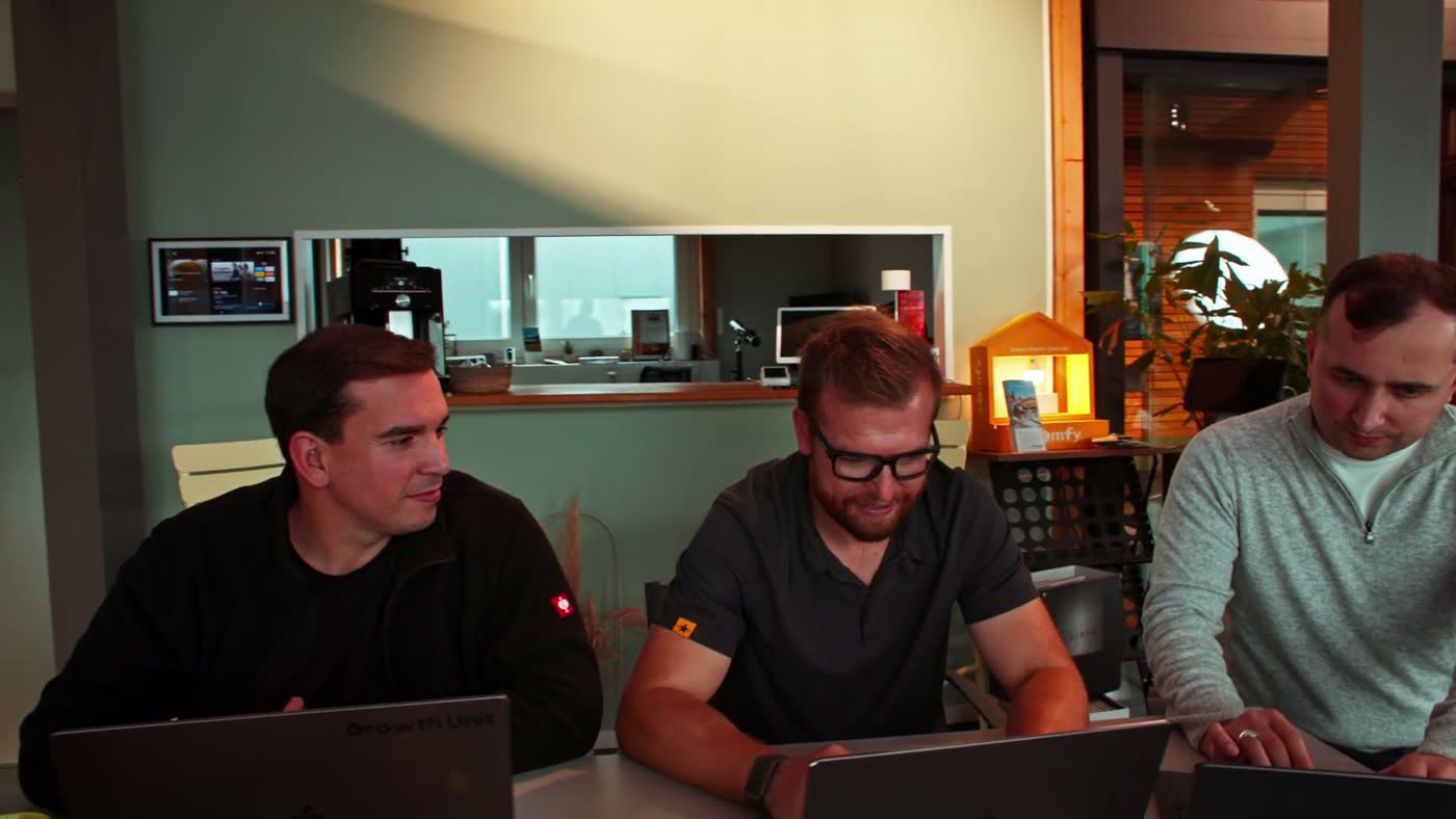 Felix Till mit dem Growth-Unit-Team am Laptop im Showroom